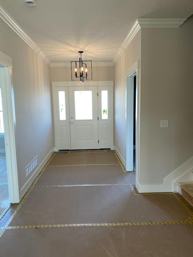 foyer entrance with concrete flooring, visible vents, baseboards, ornamental molding, and an inviting chandelier