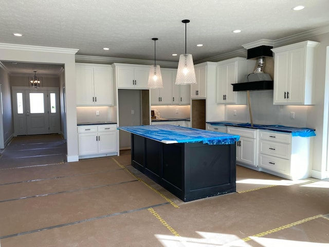 kitchen featuring recessed lighting, white cabinetry, a center island, dark countertops, and crown molding