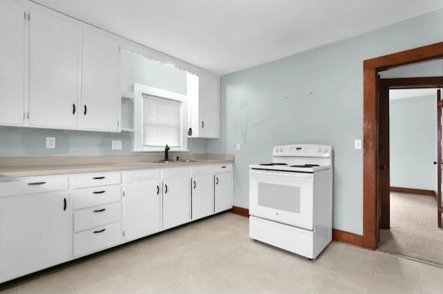 kitchen with electric range, a sink, white cabinetry, baseboards, and light countertops