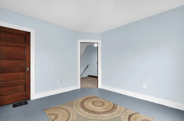 unfurnished room featuring concrete floors, visible vents, and baseboards