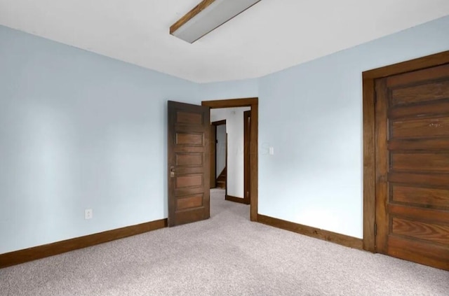 carpeted spare room featuring baseboards