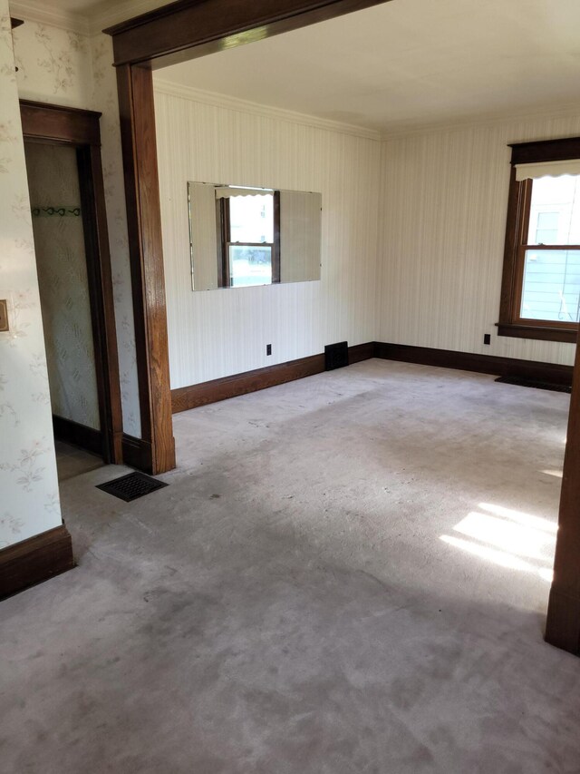 unfurnished room featuring wallpapered walls, crown molding, baseboards, and carpet flooring