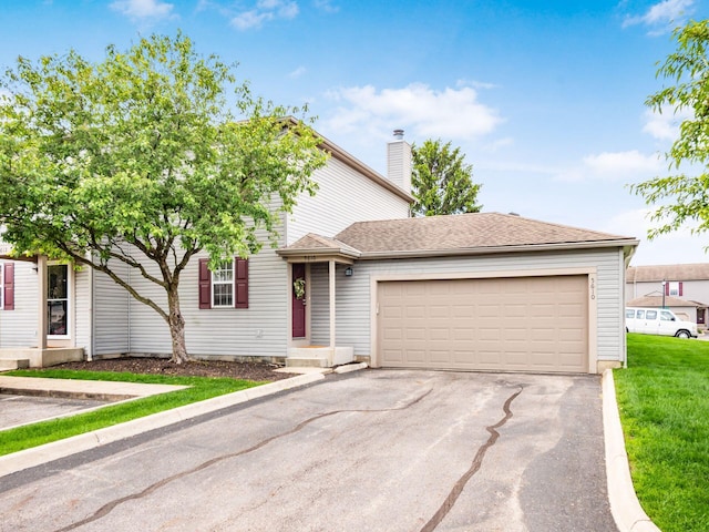 5610 Barney Ln Unit 41F, Columbus, OH 43235 - view of front of house with an attached garage, driveway, and a chimney