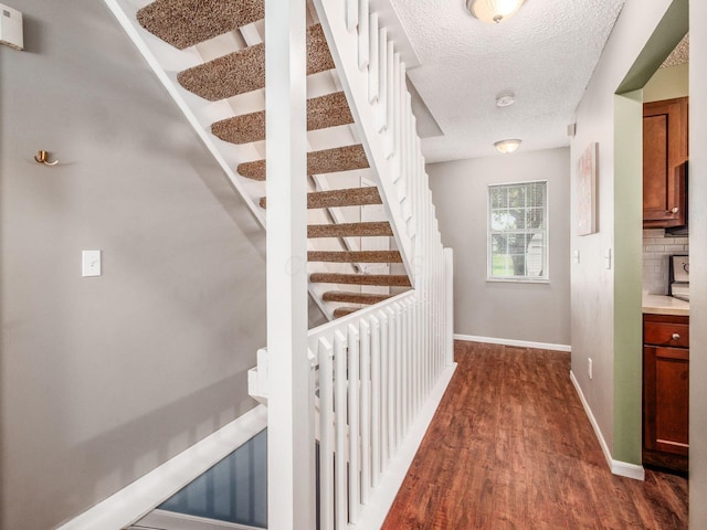 5610 Barney Ln Unit 41F, Columbus, OH 43235 - corridor with dark wood-type flooring, baseboards, a textured ceiling, and stairs