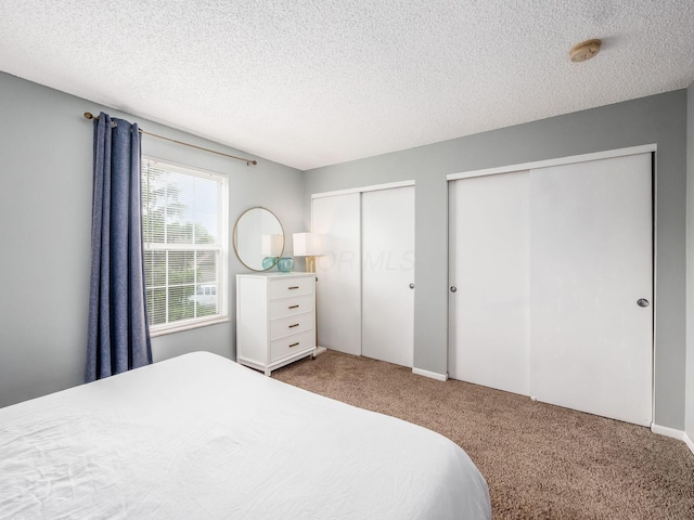 5610 Barney Ln Unit 41F, Columbus, OH 43235 - bedroom featuring carpet, multiple closets, and a textured ceiling