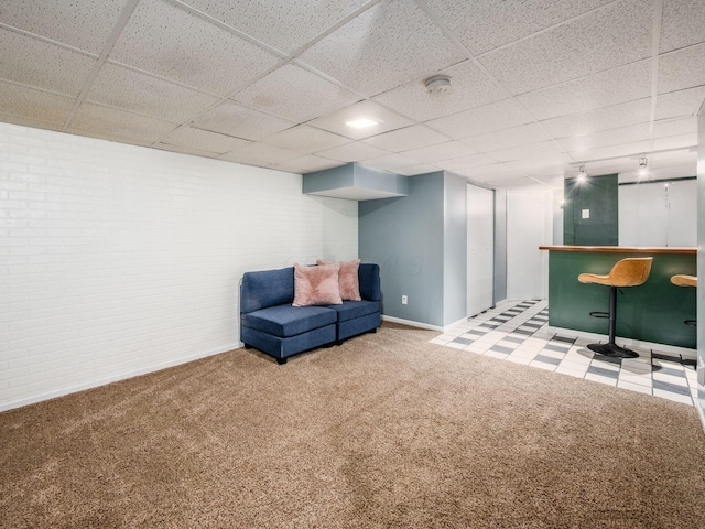 5610 Barney Ln Unit 41F, Columbus, OH 43235 - sitting room featuring a dry bar, carpet, a drop ceiling, baseboards, and brick wall