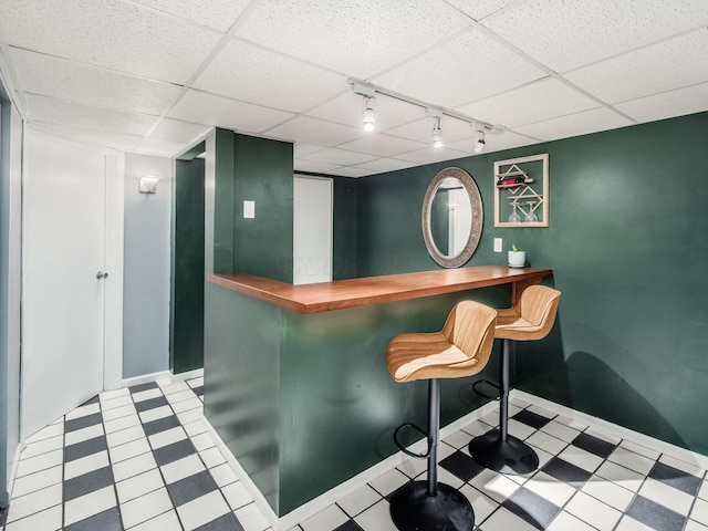 5610 Barney Ln Unit 41F, Columbus, OH 43235 - indoor dry bar featuring track lighting, baseboards, a paneled ceiling, and tile patterned floors