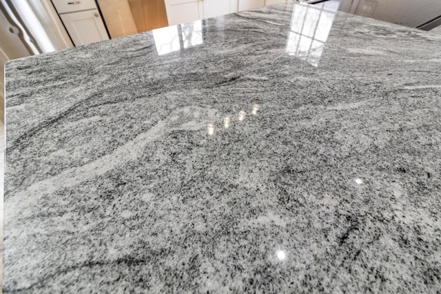 interior details with stone countertops and white cabinets