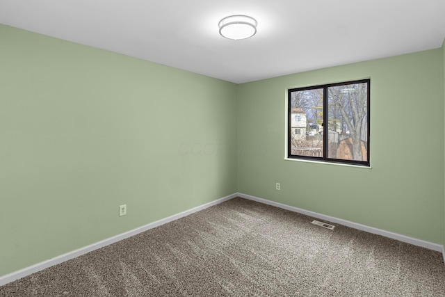 empty room with carpet floors, visible vents, and baseboards