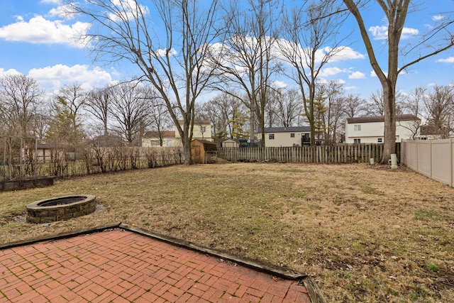 view of yard featuring a fire pit, a patio, and a fenced backyard