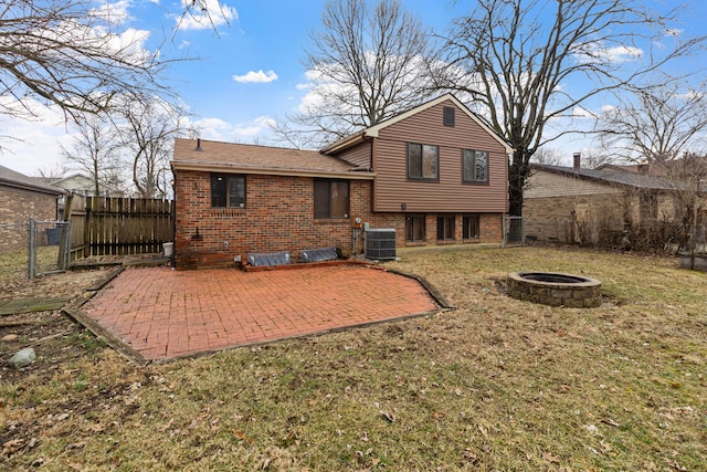 rear view of property with an outdoor fire pit, fence, cooling unit, a patio area, and brick siding