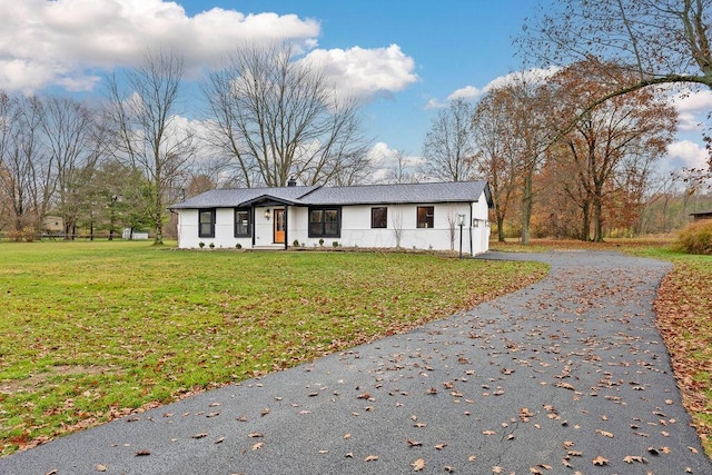 view of front of property featuring aphalt driveway and a front lawn