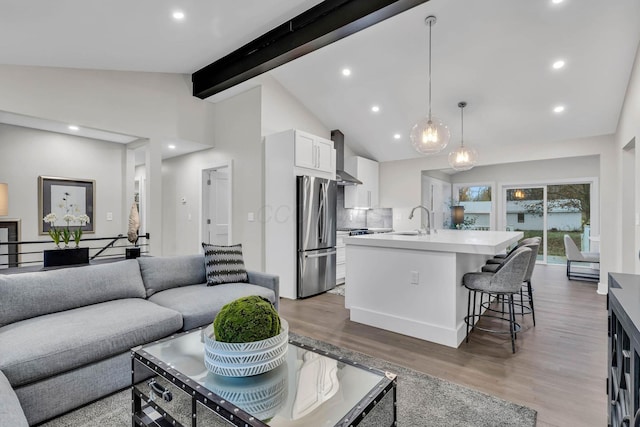 living area featuring high vaulted ceiling, recessed lighting, beam ceiling, and light wood-style floors