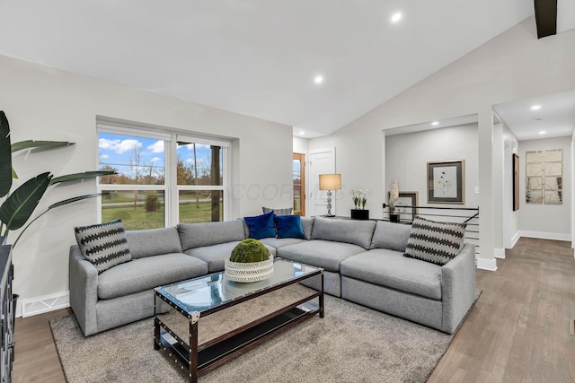 living room featuring high vaulted ceiling, baseboards, wood finished floors, and recessed lighting