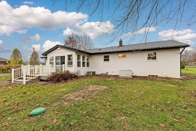 rear view of property with a deck, central AC, a sunroom, a yard, and a chimney