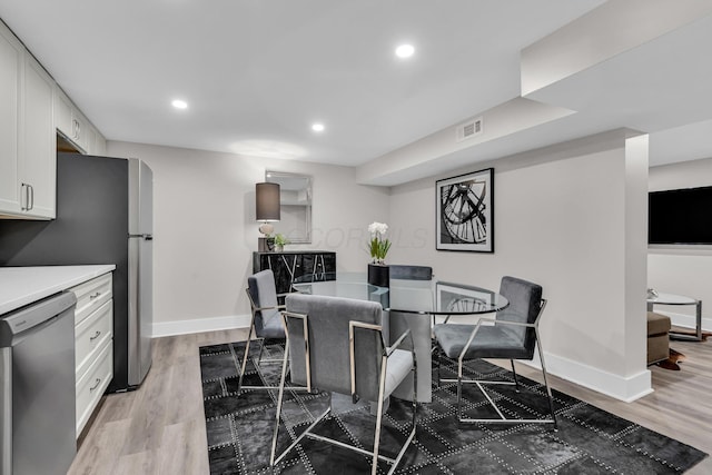 dining space with baseboards, visible vents, wood finished floors, and recessed lighting