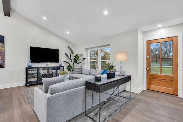 living room with baseboards, vaulted ceiling, wood finished floors, and recessed lighting