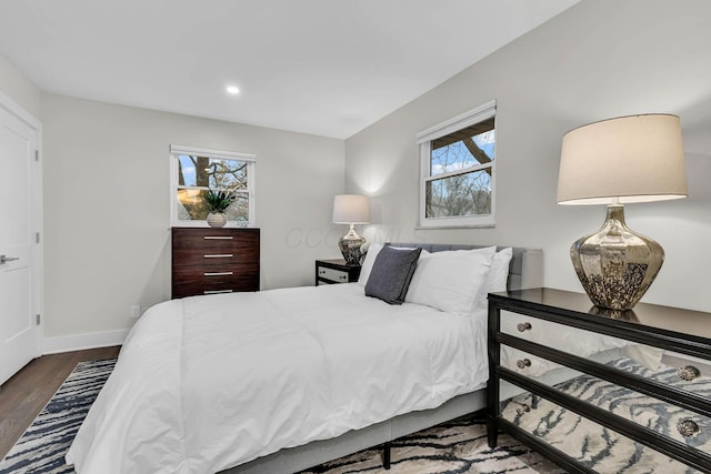 bedroom with baseboards, wood finished floors, and recessed lighting