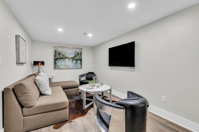 living room featuring visible vents, baseboards, wood finished floors, and recessed lighting