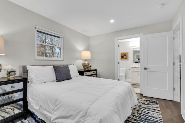 bedroom with ensuite bath, wood finished floors, and recessed lighting