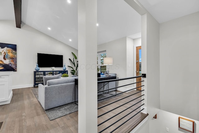 living area featuring vaulted ceiling with beams, baseboards, wood finished floors, and recessed lighting