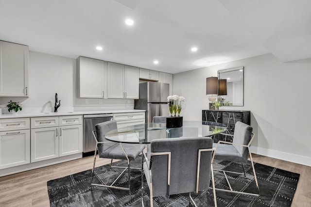 kitchen with stainless steel appliances, recessed lighting, a sink, and light wood-style flooring