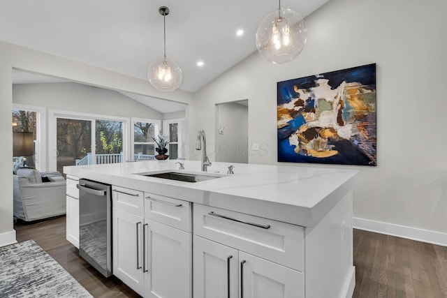 kitchen featuring lofted ceiling, an island with sink, a sink, and dark wood finished floors