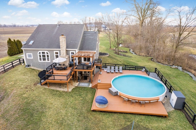 view of swimming pool featuring a fenced in pool, a yard, fence, and a deck