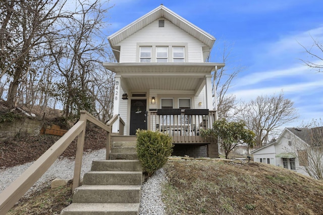 view of front of property featuring covered porch and stairway