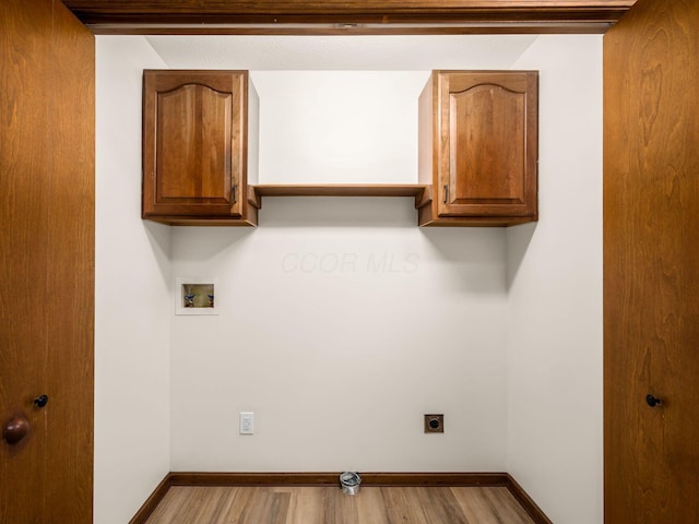 laundry room featuring hookup for a washing machine, wood finished floors, baseboards, cabinet space, and electric dryer hookup