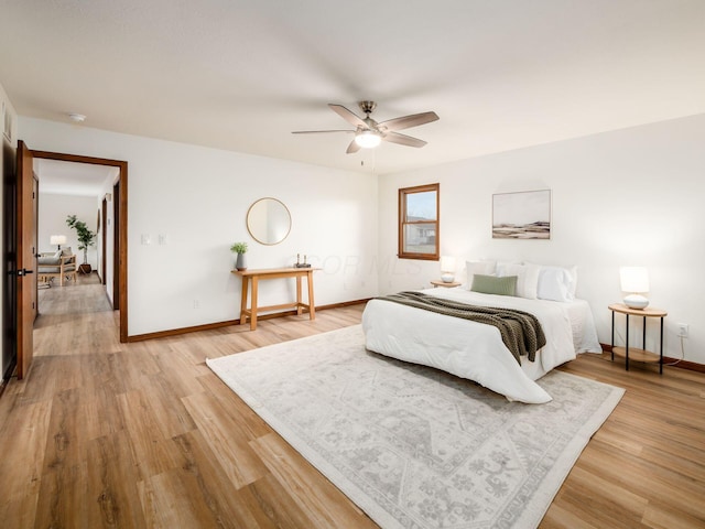 bedroom featuring a ceiling fan, light wood-type flooring, and baseboards