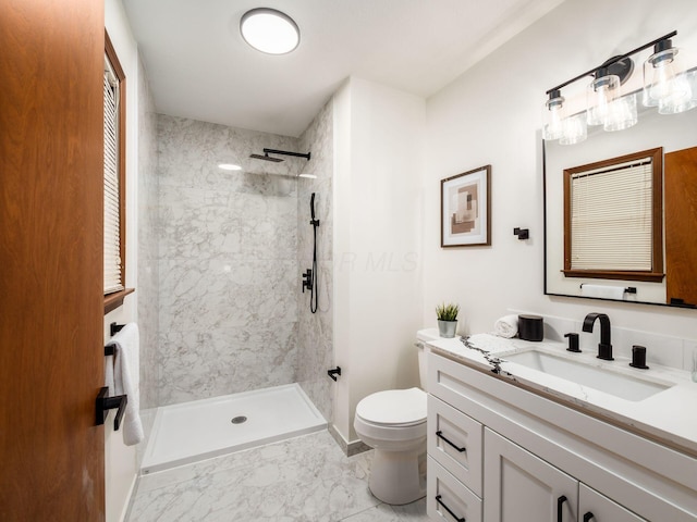 full bath with toilet, marble finish floor, a tile shower, and vanity