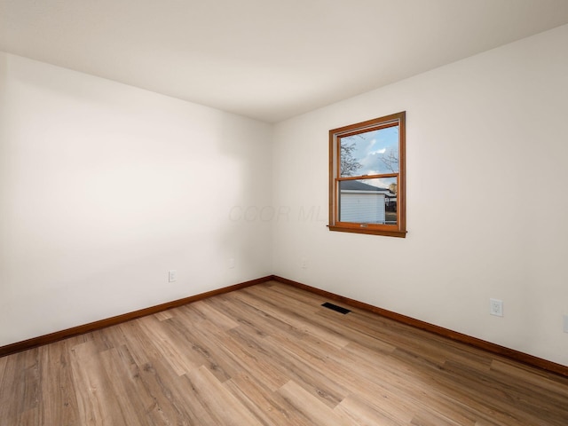 unfurnished room with baseboards, visible vents, and light wood finished floors