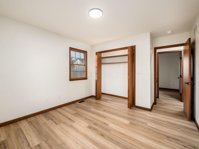 unfurnished bedroom with light wood-style flooring, visible vents, and baseboards