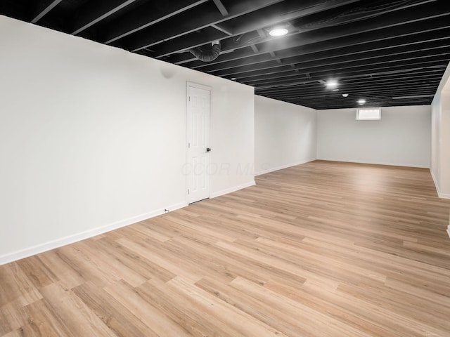 below grade area with light wood-style floors and baseboards