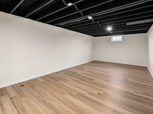 basement featuring wood finished floors and baseboards