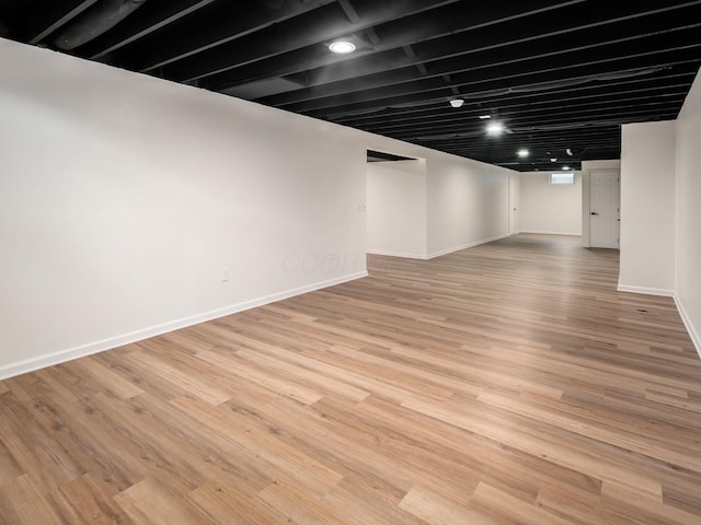 finished below grade area featuring baseboards and wood finished floors