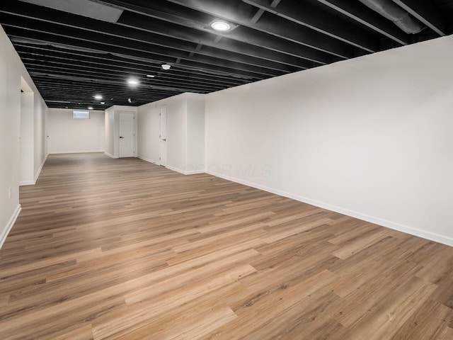 finished basement featuring baseboards and wood finished floors