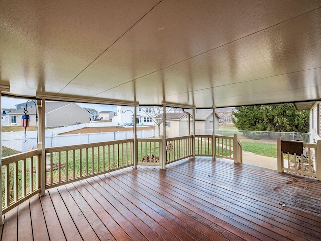 deck featuring a shed, a lawn, a fenced backyard, and an outbuilding