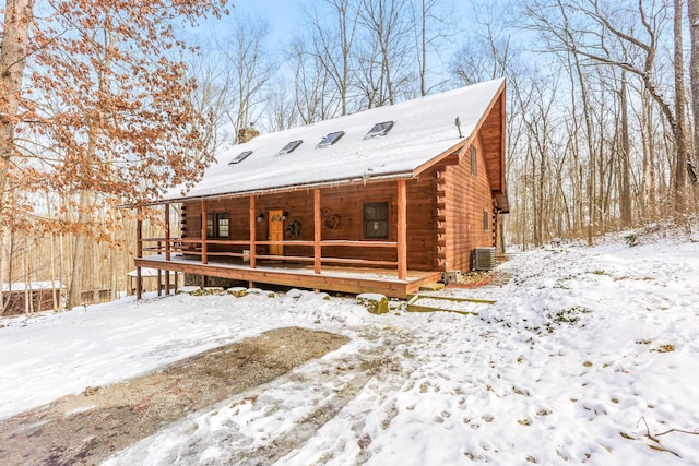 log-style house with a chimney, covered porch, central AC, and log exterior