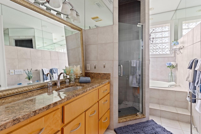 full bath featuring vanity, tile walls, a stall shower, and tile patterned floors
