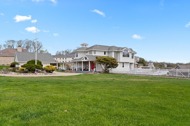 view of front of house with a front yard and fence