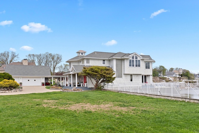 view of front of home featuring concrete driveway, a front yard, and fence