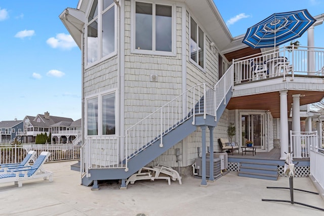 rear view of property featuring stairs, a patio, a deck, and central AC