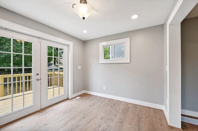 doorway featuring plenty of natural light, light wood-style flooring, and baseboards