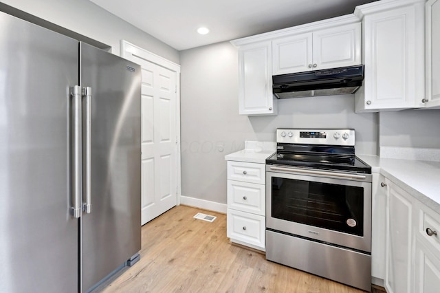 kitchen with stainless steel appliances, light countertops, white cabinetry, and under cabinet range hood