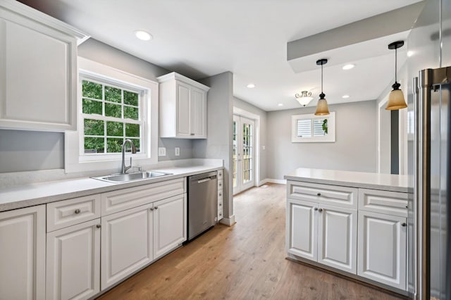 kitchen with french doors, light countertops, white cabinetry, a sink, and dishwasher