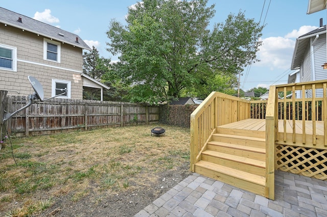 view of yard with an outdoor fire pit, a fenced backyard, stairway, and a wooden deck