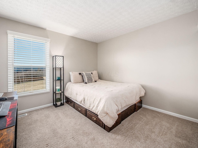 carpeted bedroom featuring baseboards, visible vents, and a textured ceiling