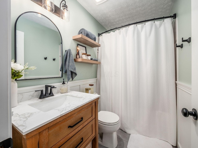 bathroom featuring toilet, vanity, a shower with curtain, tile patterned floors, and a textured ceiling